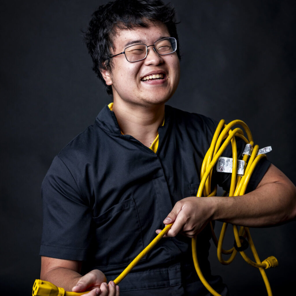 man holding an extension cord smiling