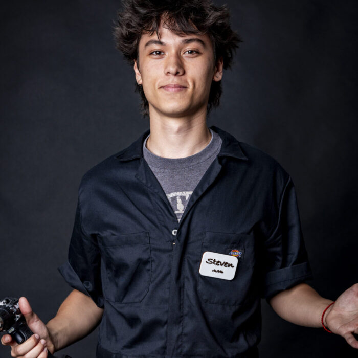 man smiling in black jumpsuit