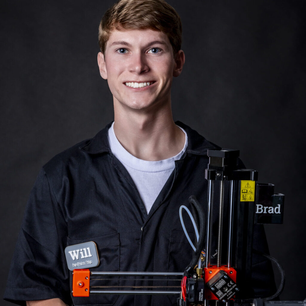 man holding a 3d printer smiling