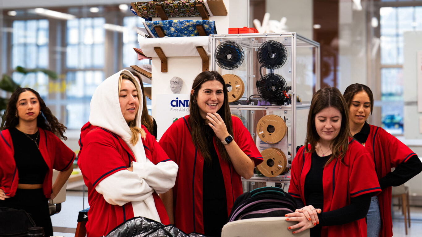 A group of students from a dance team organization, all dressed in matching red shirts, gathered for a collaborative activity.