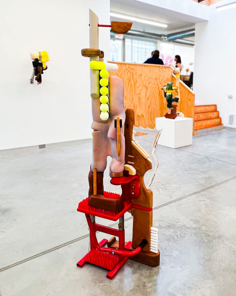 Colorful abstract sculpture displayed in a modern gallery space with visitors in the background.