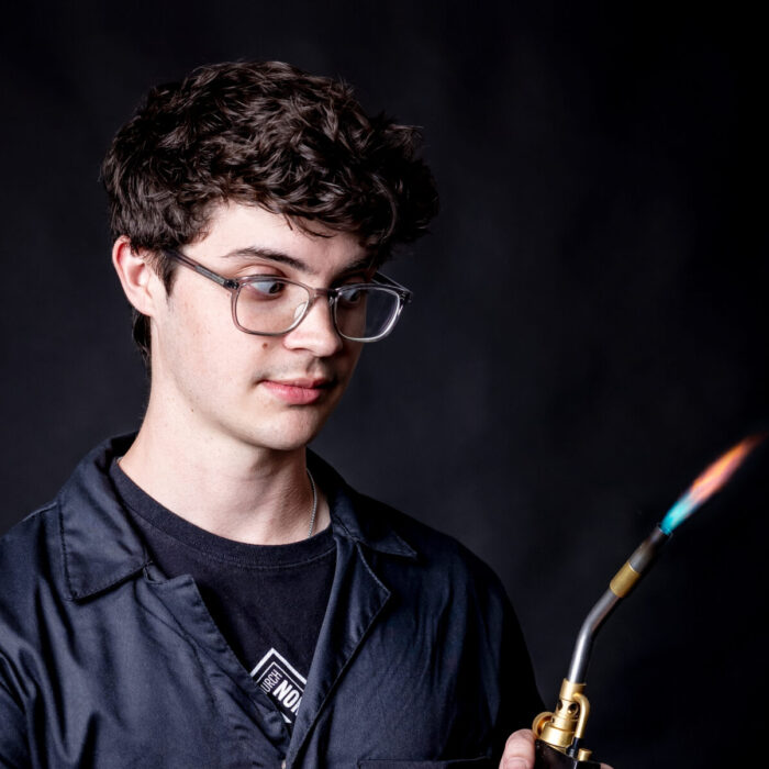 student portrait holding a blow torch