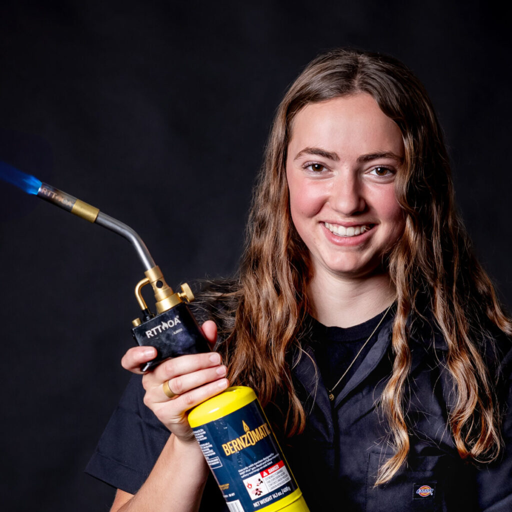 student portrait holding a blow torch